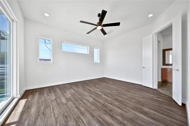 a view of empty room with wooden floor and window