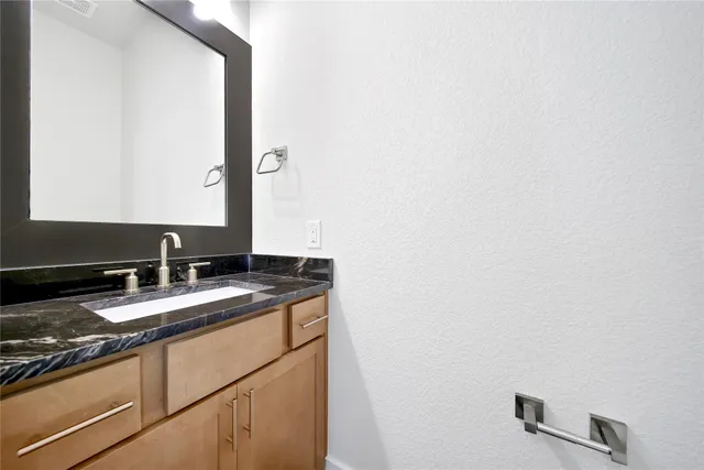 a bathroom with a granite countertop sink and a mirror