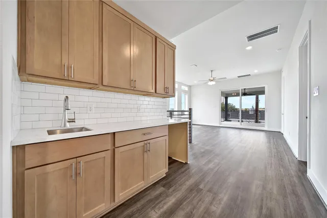 a kitchen with white cabinets and sink