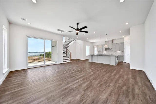 a view of an empty room with a kitchen and wooden floor