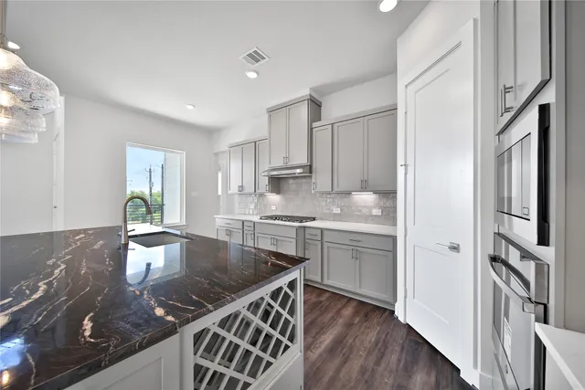 a kitchen with stainless steel appliances granite countertop a sink stove and refrigerator