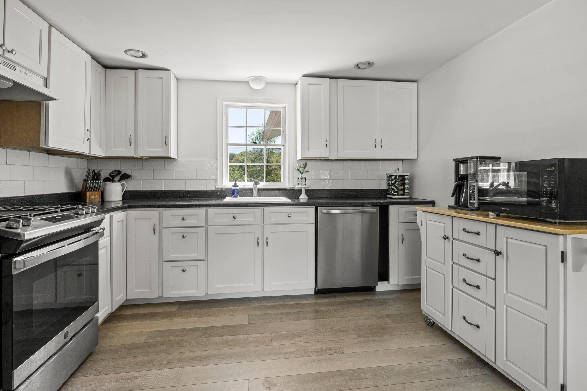 91 Sterling Road Hyannis, MA 02601 - Photo 3 of 31 a kitchen with white cabinets sink and stainless steel appliances