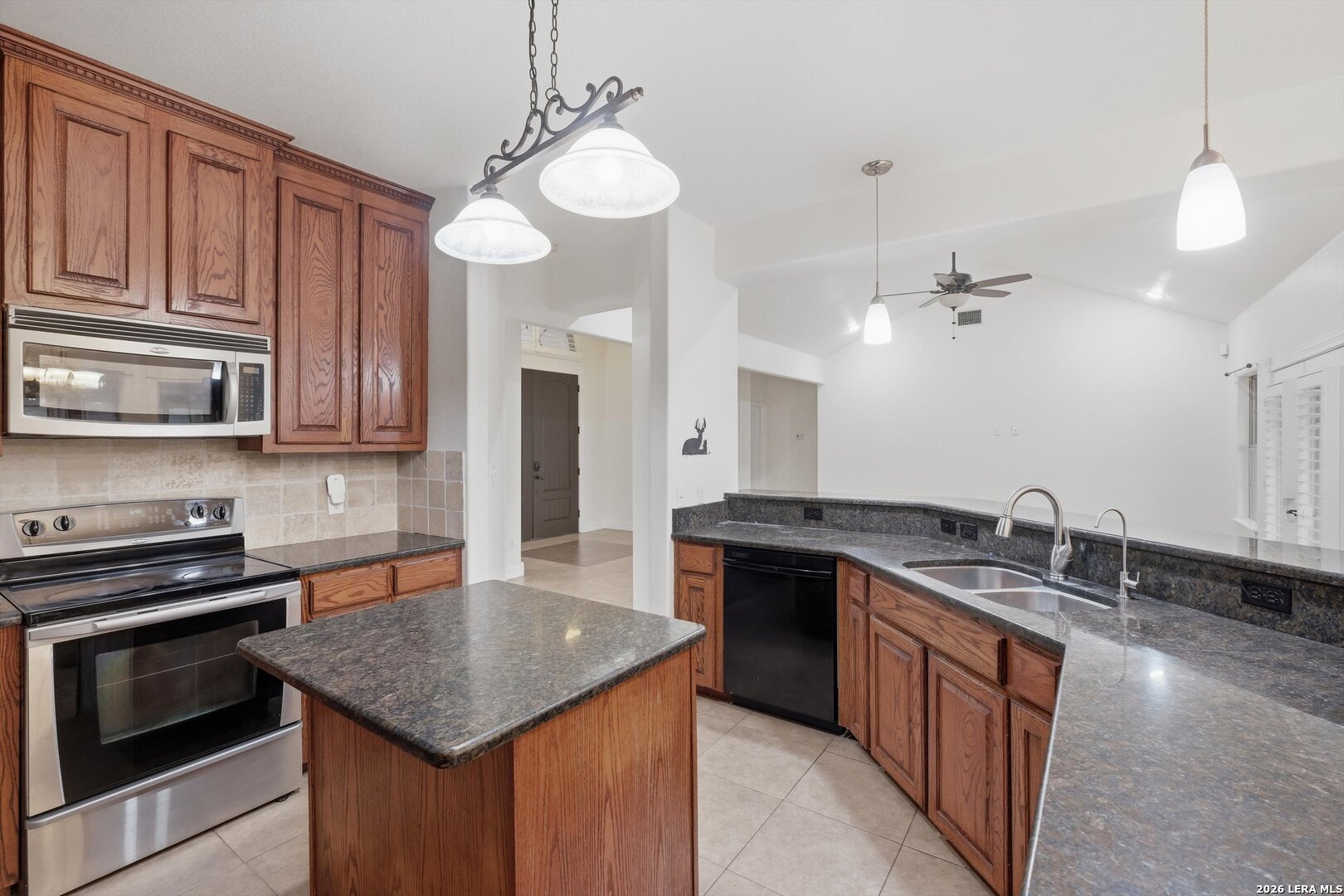 101 Lynx Circle Devine, TX 78016 - Photo 13 of 36 a kitchen with stainless steel appliances granite countertop a sink stove and cabinets