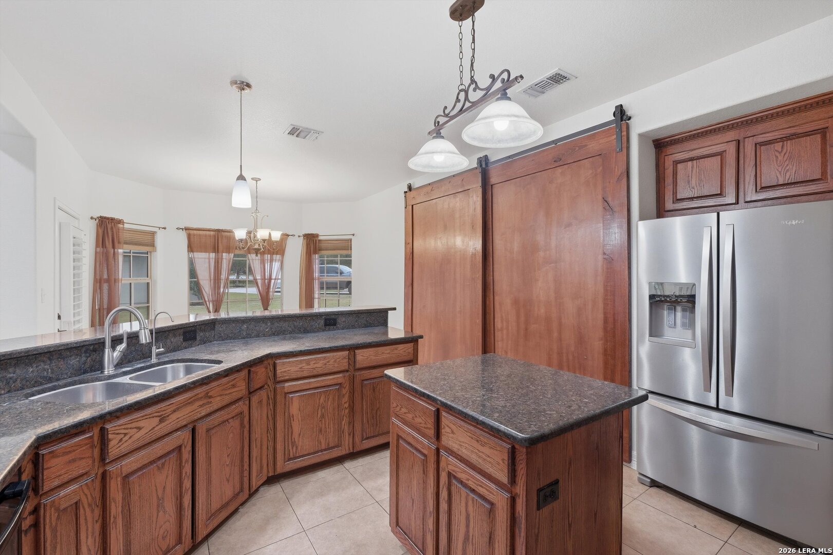 101 Lynx Circle Devine, TX 78016 - Photo 14 of 36 a kitchen with a refrigerator a sink cabinets and wooden floor