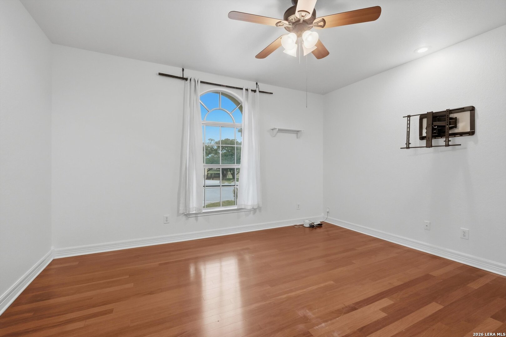 101 Lynx Circle Devine, TX 78016 - Photo 17 of 36 an empty room with wooden floor fan and windows