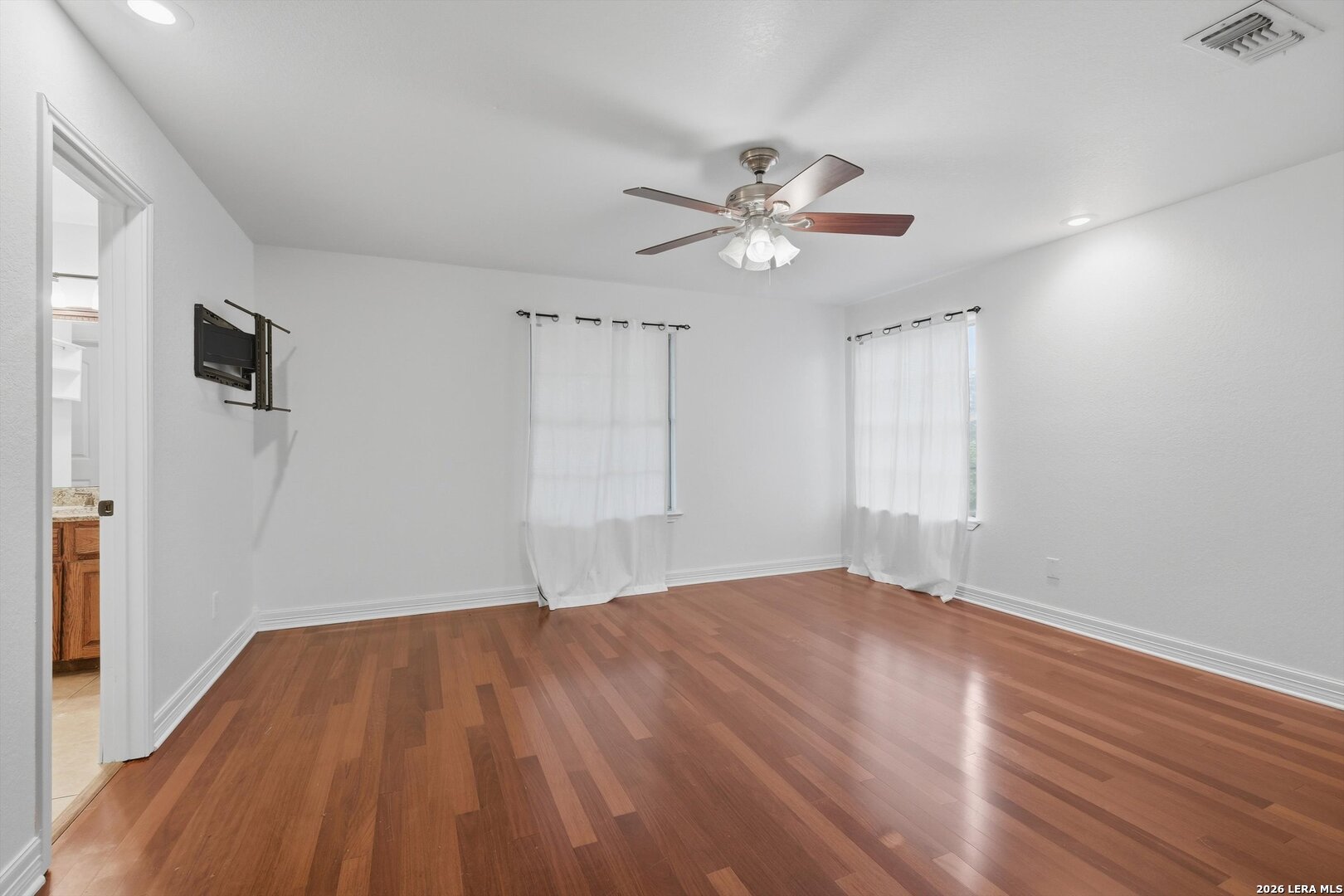 101 Lynx Circle Devine, TX 78016 - Photo 19 of 36 a view of empty room with wooden floor and fan