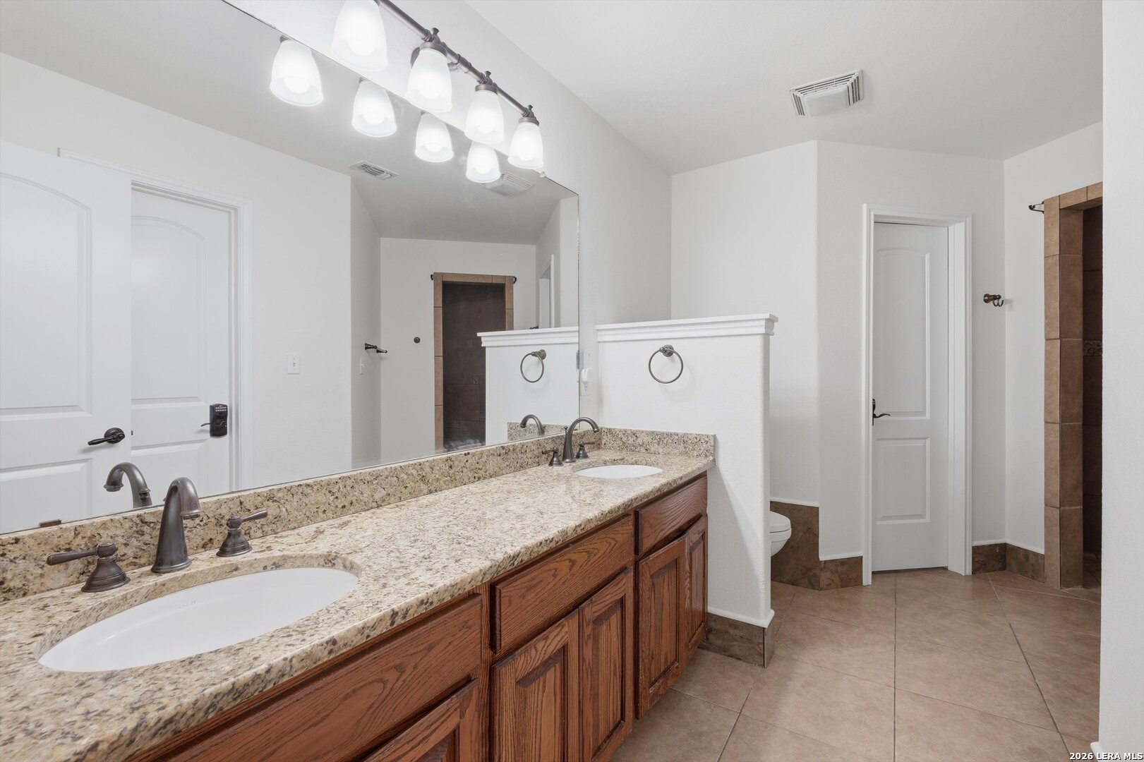 101 Lynx Circle Devine, TX 78016 - Photo 25 of 36 a bathroom with a granite countertop sink and a mirror