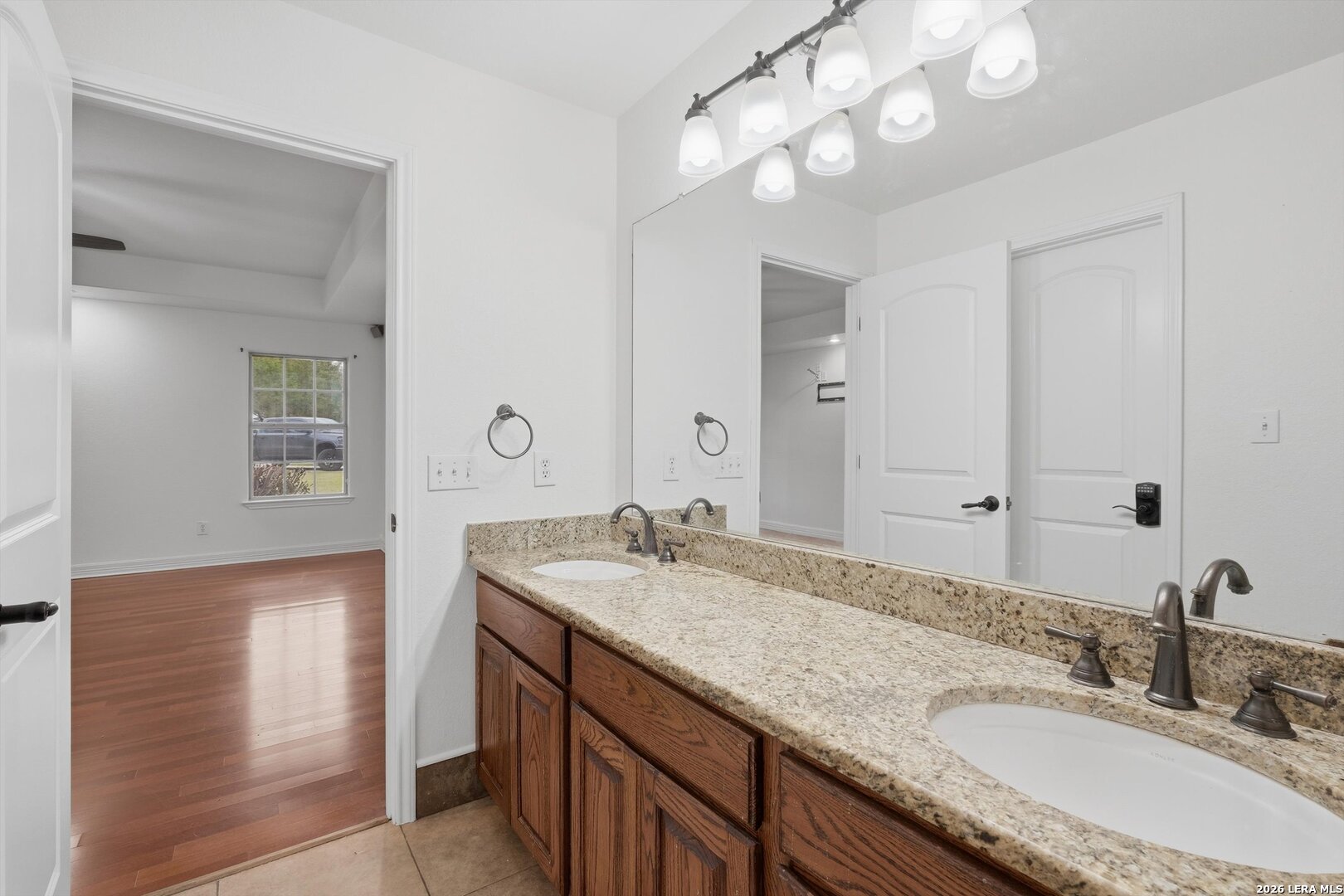 101 Lynx Circle Devine, TX 78016 - Photo 26 of 36 a bathroom with a granite countertop double vanity sink and a mirror