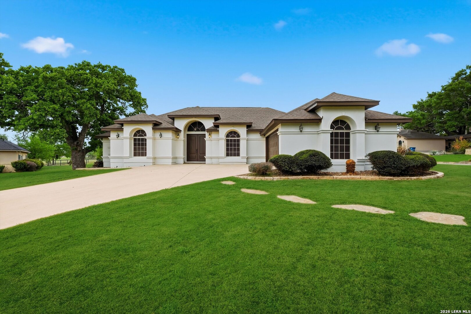 101 Lynx Circle Devine, TX 78016 - Photo 4 of 36 a front view of a house with a garden and yard