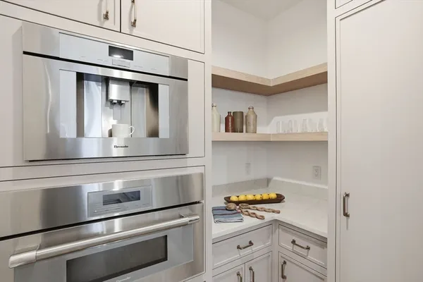 a kitchen with white cabinets and appliances