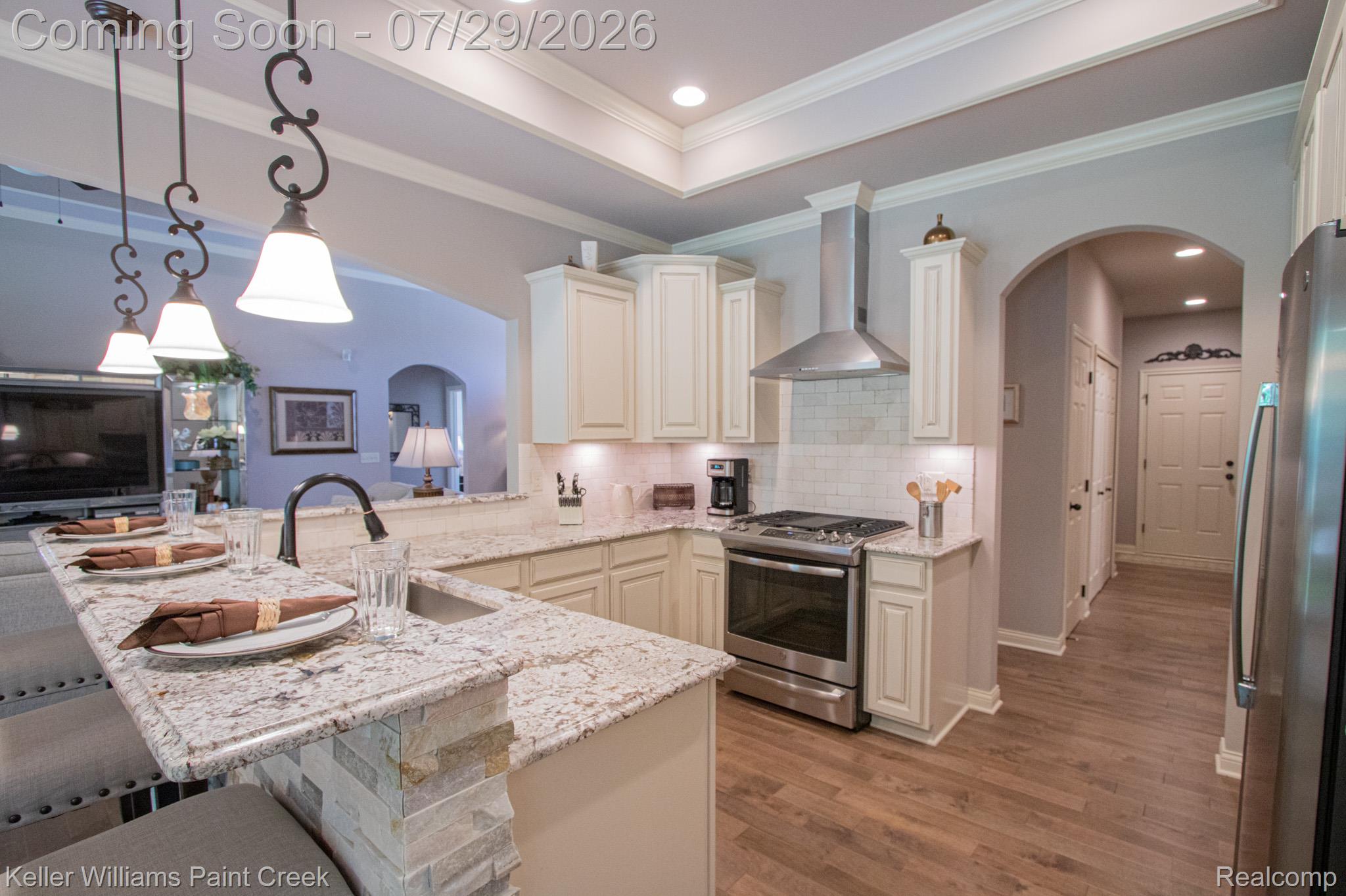 49118 Ridgeview Drive Macomb, MI 48044 - Photo 16 of 57 Kitchen featuring granite countertops, stainless steel appliances, cream cabinetry, a tile backsplash, and wood-finish flooring