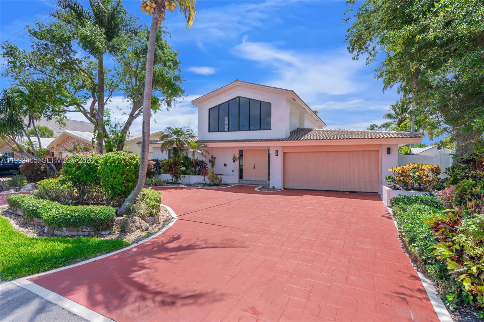 2858 Northeast 33rd Street Lighthouse Point, FL 33064 - Photo 16 of 24 a front view of a house with a yard and garage