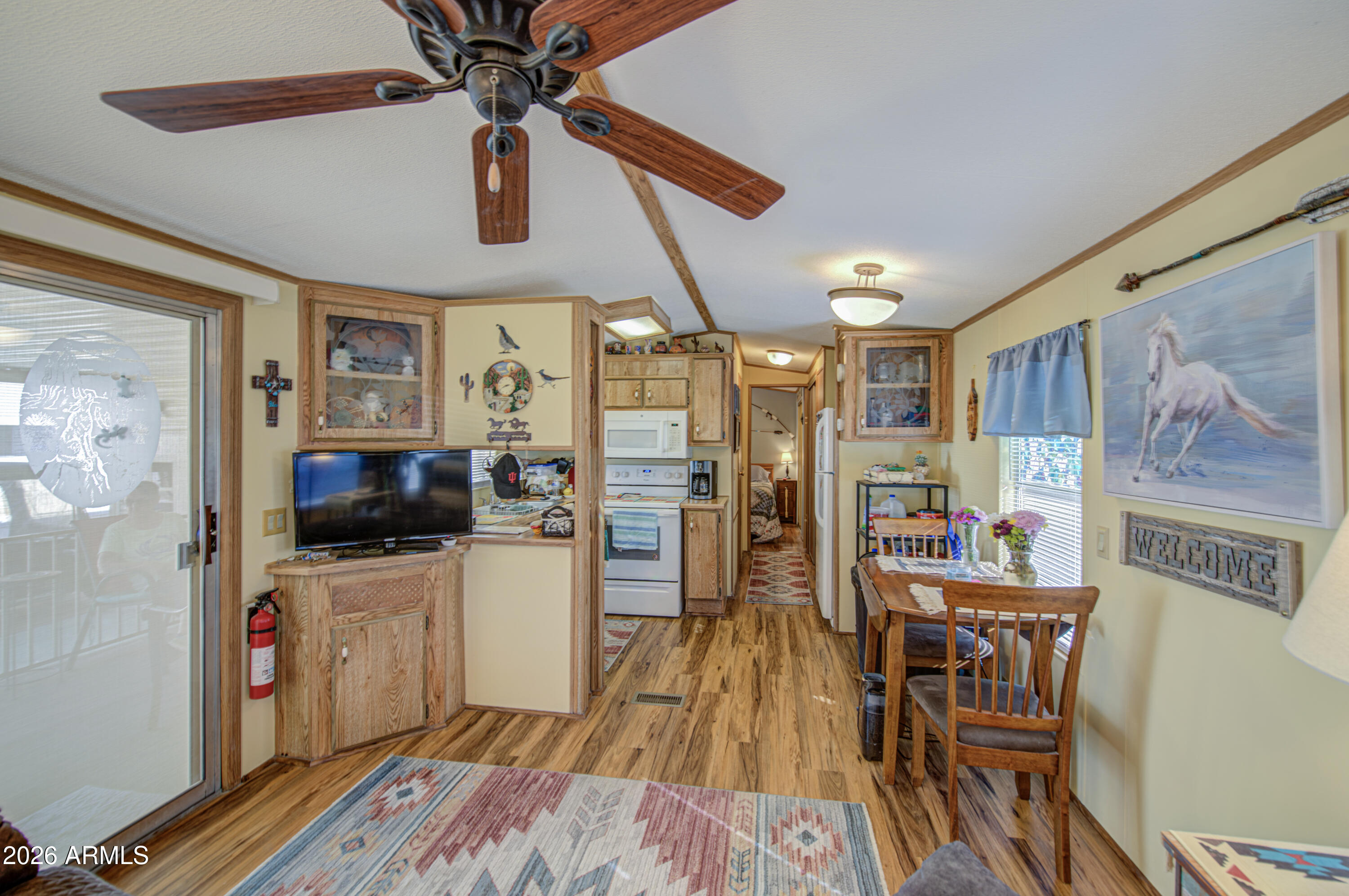 7750 East Broadway Road, Unit 463 Mesa, AZ 85208 - Photo 22 of 36 a kitchen with stainless steel appliances a stove a refrigerator a dining table and chairs with wooden floor