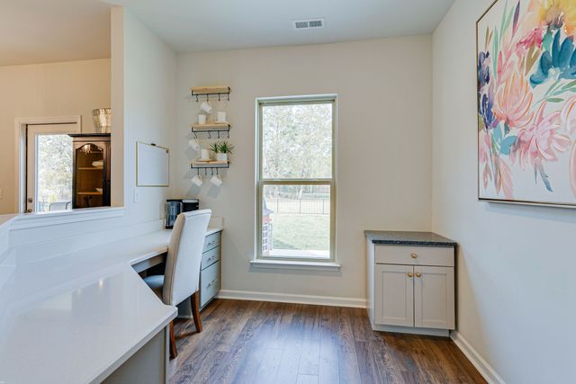 a view of hallway with window and wooden floor
