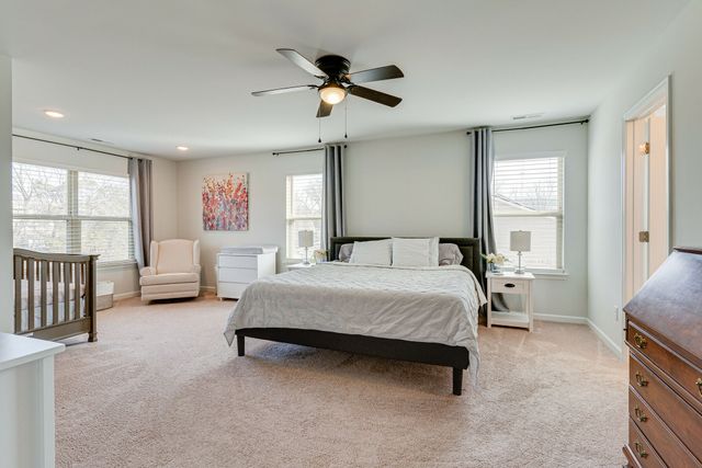 a spacious bedroom with a bed couch and a large window