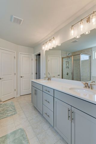 a spacious bathroom with a granite countertop sink mirror and cabinets