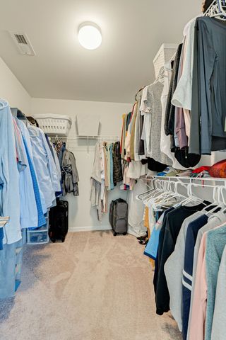 a view of walk in closet with clothes and shoes
