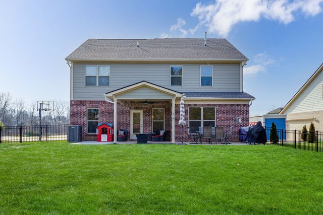 a front view of a house with a garden and yard