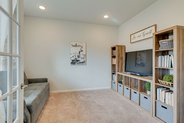 a living room with flat screen tv and a book shelf