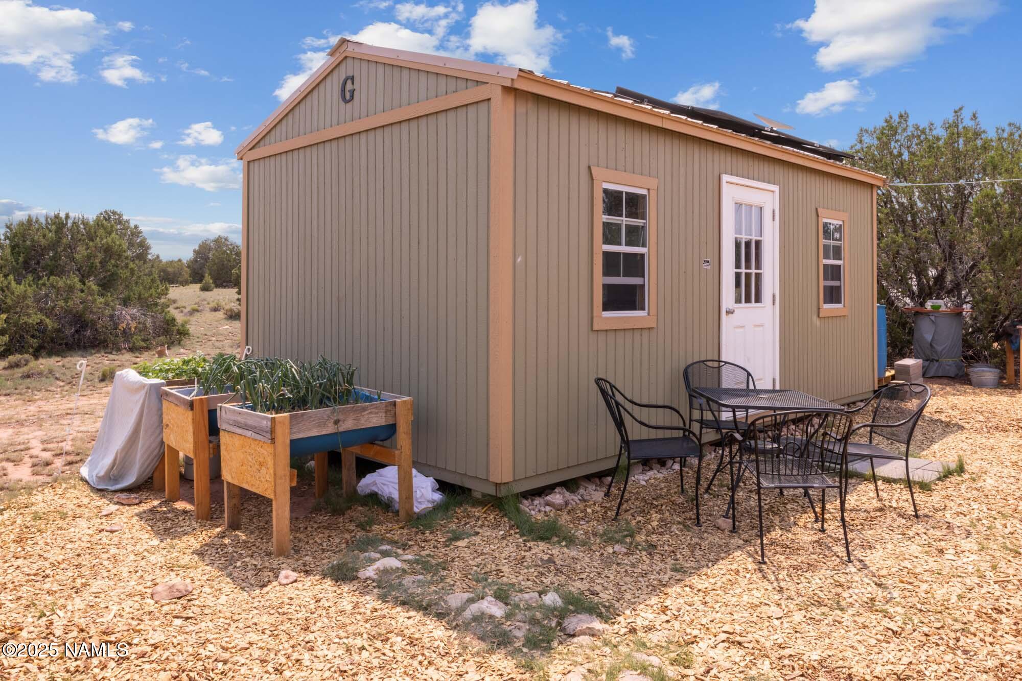 10448 South Rim Ranch Road Williams, AZ 86046 - Photo 8 of 60 a backyard of a house with barbeque oven table and chairs