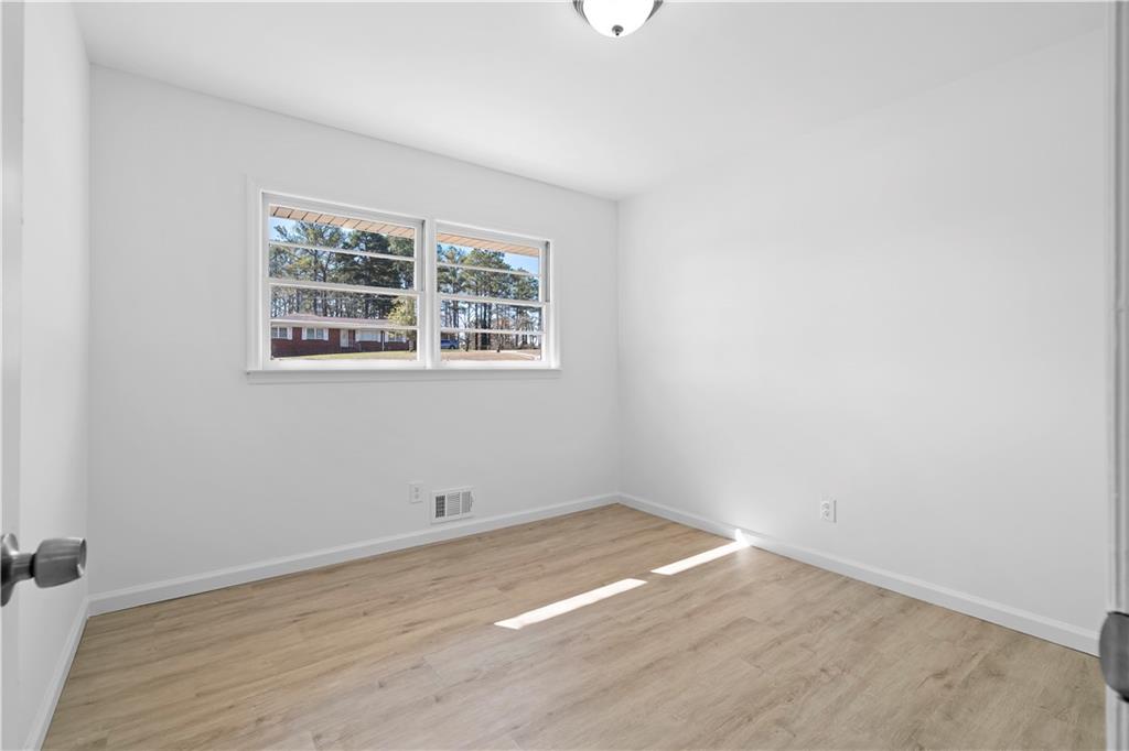 1802 Lake Harbin Road Morrow, GA 30260 - Photo 23 of 40 an empty room with wooden floor and windows