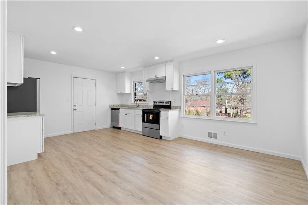 1802 Lake Harbin Road Morrow, GA 30260 - Photo 8 of 40 a large white kitchen with kitchen island a sink stainless steel appliances and cabinets