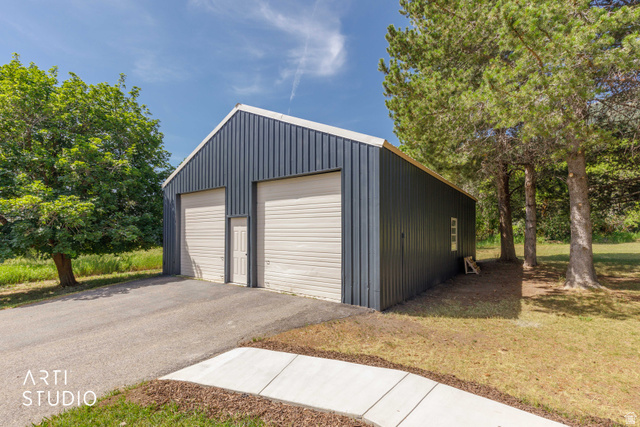 2807 North Ogden Canyon Road Eden, UT 84310 - Photo 46 of 72 Freestanding outbuilding with two garage doors and a pedestrian entry door, featuring corrugated metal siding and a pitched roof