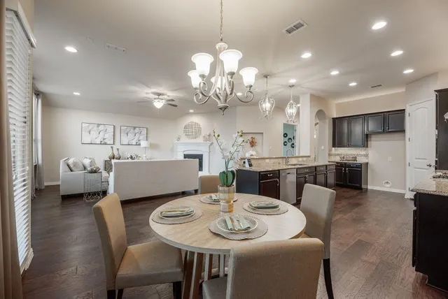 a living room with furniture kitchen view and a chandelier