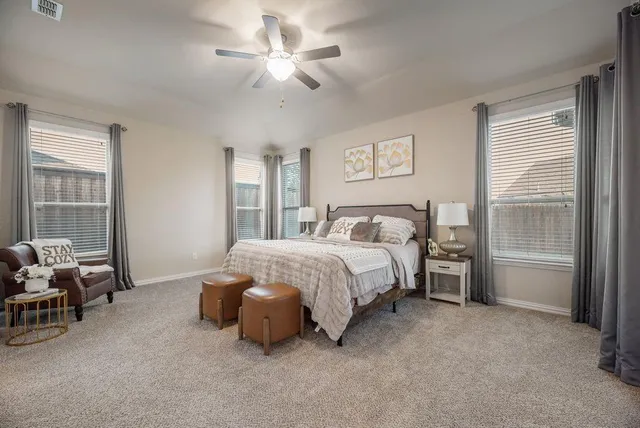 a spacious bedroom with a bed and a chandelier