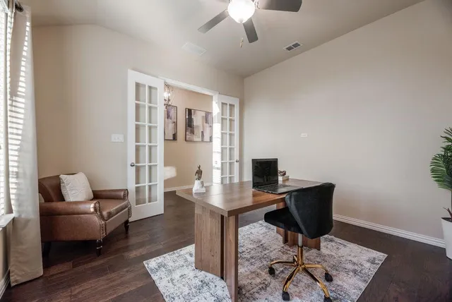 a view of a workspace with furniture and a window