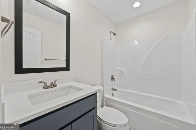 a bathroom with a granite countertop sink toilet a mirror and shower