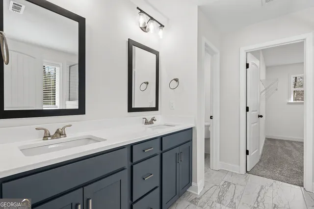 a bathroom with a double vanity sink and mirror