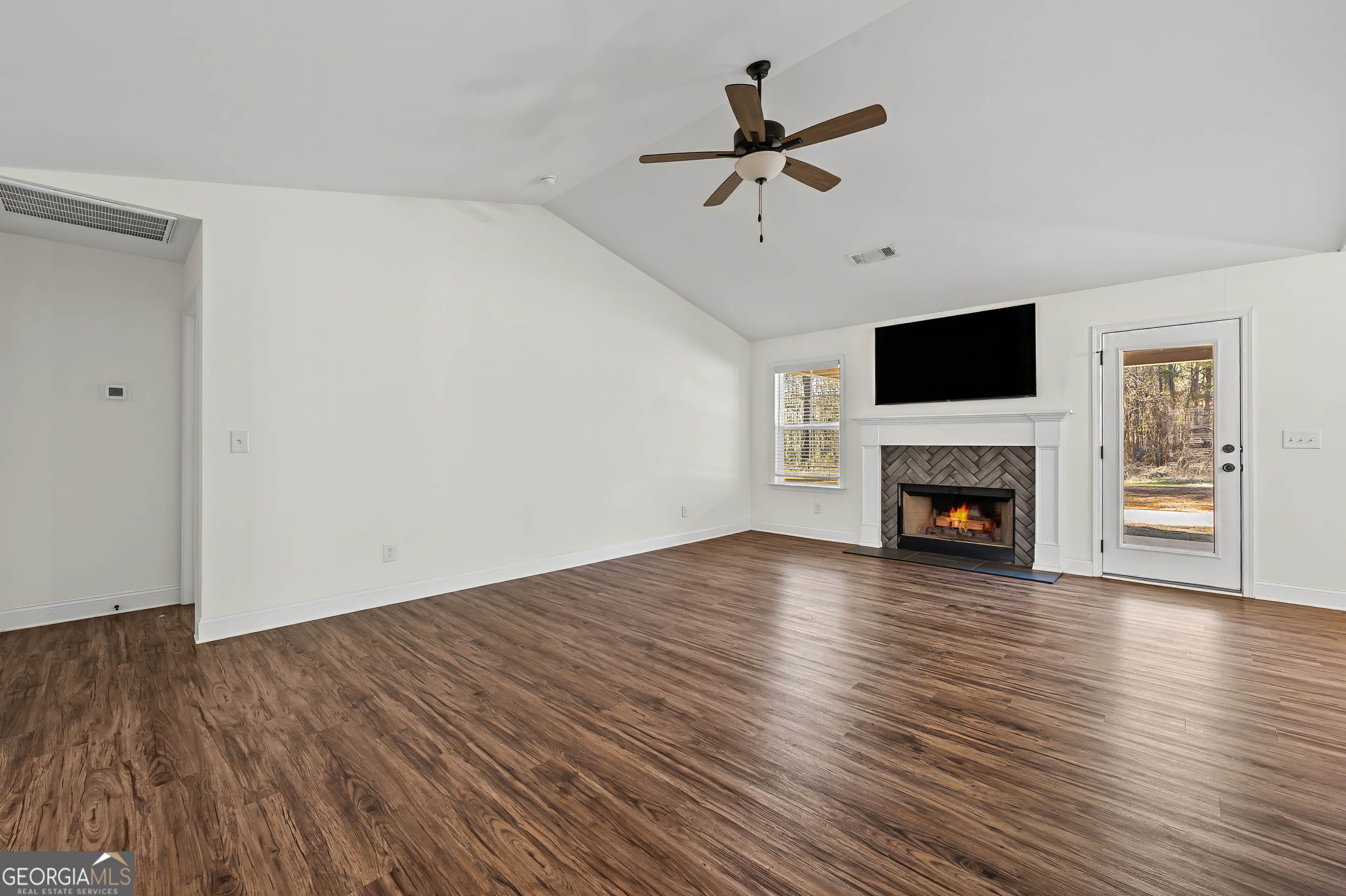 1788 Standing Rock Road Senoia, GA 30276 - Photo 9 of 36 a view of empty room with wooden floor and fireplace