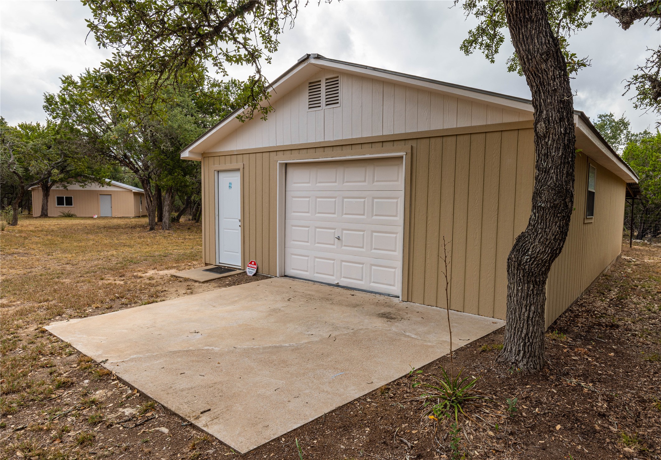 2501 Fischer Store Road Wimberley, TX 78676 - Photo 18 of 23 Detached garage structure featuring a single garage door and separate entry door