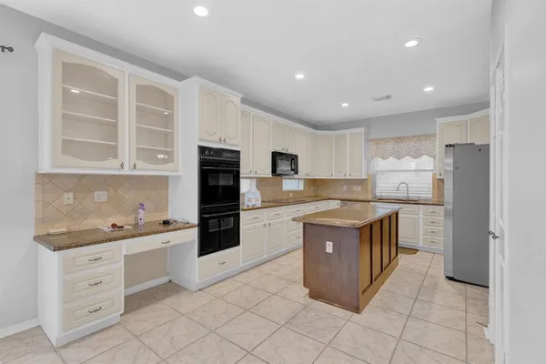 a kitchen with stainless steel appliances granite countertop a stove top oven and cabinets