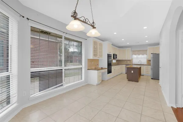 a open kitchen with a refrigerator a kitchen island a stove and a cabinets