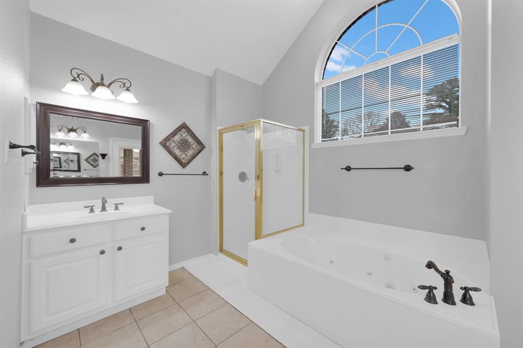 3714 Cedar Glen Lane Spring, TX 77388 - Photo 16 of 29 Full bath featuring a shower stall, a jetted tub, vanity, light tile patterned flooring, and lofted ceiling