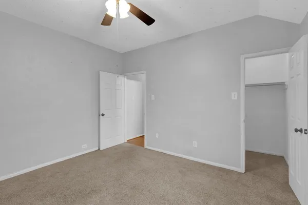 an empty room with a chandelier fan