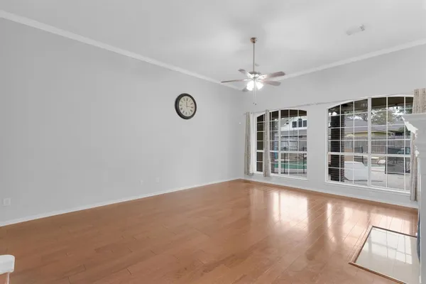a view of an empty room with a window and wooden floor