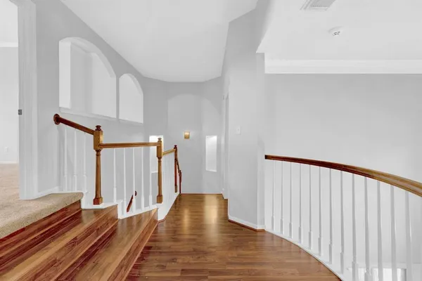 a view of a hallway with wooden floor and staircase