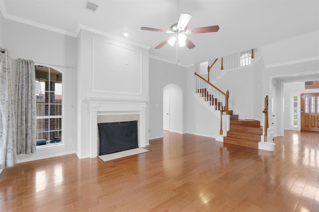 3714 Cedar Glen Lane Spring, TX 77388 - Photo 8 of 29 Unfurnished living room with ornamental molding, light wood-type flooring, a fireplace with flush hearth, a ceiling fan, and a high ceiling