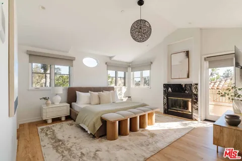 a bedroom with bed and flat tv with wooden floor
