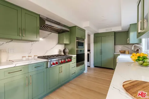 a kitchen with granite countertop a stove and a wooden cabinets