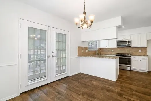 a kitchen with stainless steel appliances granite countertop a refrigerator and a stove top oven