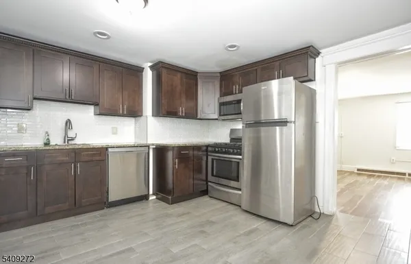 a kitchen with a refrigerator sink and cabinets