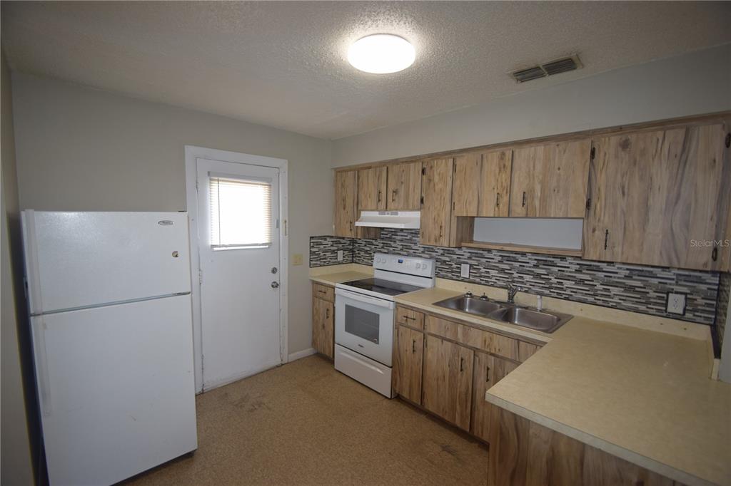 115 Leelon Road, Unit 115 Lakeland, FL 33809 - Photo 7 of 14 a kitchen with a refrigerator sink and cabinets