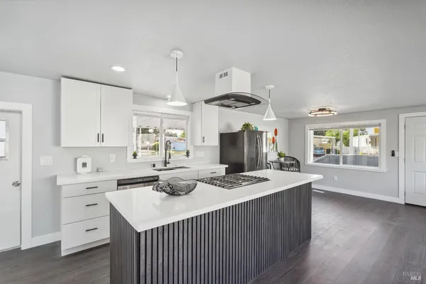 a kitchen with stainless steel appliances kitchen island granite countertop a sink and cabinets