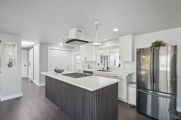 a kitchen with a stove a refrigerator and a stove top oven