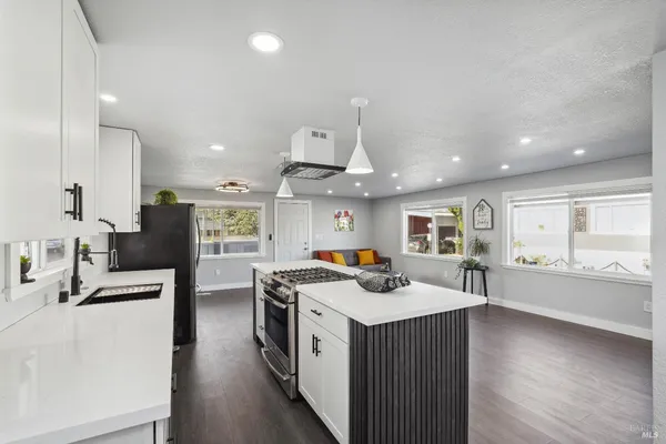 a kitchen with stainless steel appliances kitchen island granite countertop a sink counter space and cabinets