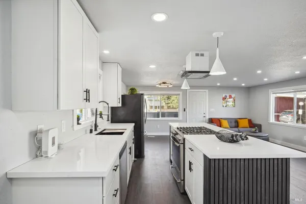 a large kitchen with a sink and refrigerator